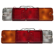 A set of two tail lights for a vehicle, featuring clear, red, and yellow lenses with metal frames.