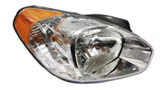 A single headlight assembly for Verna 2006-2009 with a clear lens and a wooden-colored section near the base.