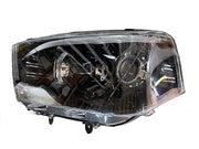A white projector headlight for the Mahindra Scorpio vehicle, showcasing the front view with clear glass and metal assembly.