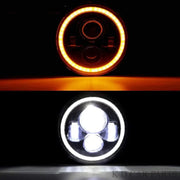 Two car headlights, one with an orange glow and the other with a white light, on a black background.