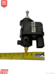 Black mechanical component with a ruler for scale on a white background