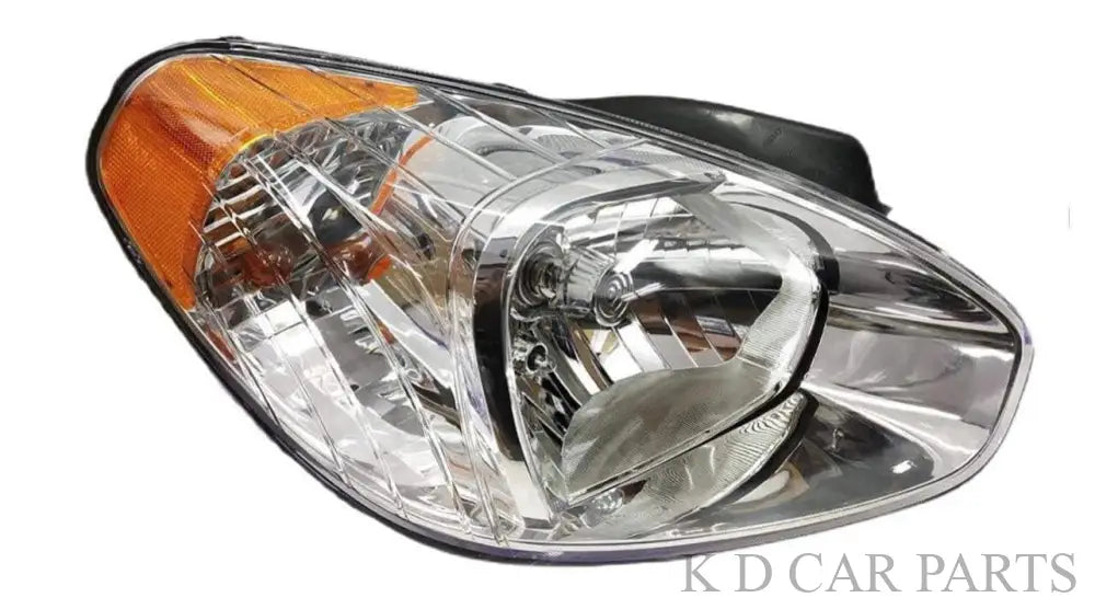 A single headlight assembly for Verna 2006-2009 with a clear lens and a wooden-colored section near the base.