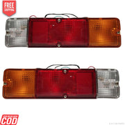 A set of two tail lights for a vehicle, featuring clear, red, and yellow lenses with metal frames.