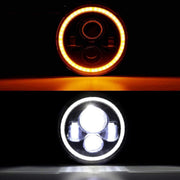 Two car headlights, one with an orange glow and the other with a white light, on a black background.